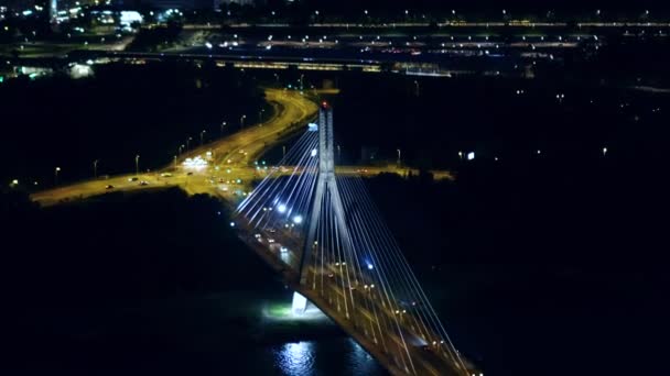 Aerial night shot of the modern guyed bridge over the Vistula river in Warsaw, Poland — Stock Video