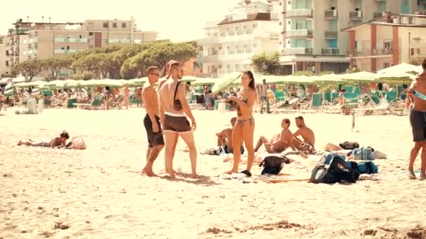 LIDO DI JESOLO, ITALIA - 8 de agosto de 2017. Los jóvenes socializan en la playa de arena — Vídeo de stock