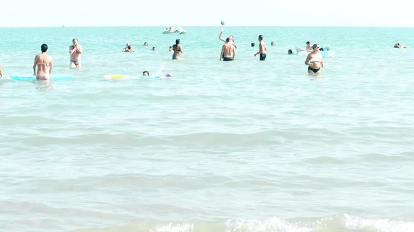 LIDO DI JESOLO, ITALIA - 8 de agosto de 2017. Gente bañándose y jugando pelota en el mar. Vacaciones de verano — Foto de Stock