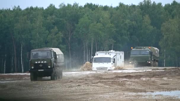 Slow motion shot of Russian KAMAZ and Ural military trucks moving through obstacles — Stock Video