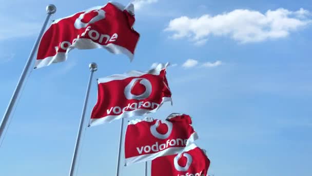 Bandiere sventolanti con logo Vodafone contro il cielo, anello senza cuciture. Animazione editoriale 4K — Video Stock