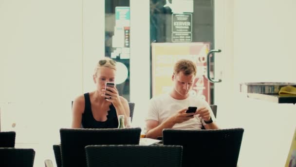 PULA, CROATIA - HARUS 4, 2017. Pasangan muda menggunakan smartphone di sebuah kafe. Kecanduan jejaring sosial modern — Stok Video
