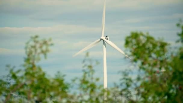 Österreich - 12. August 2017. Windgenerator hinter wehendem grünen Laub — Stockvideo