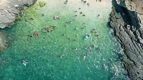 아드리아 해에 작은 붐비는 바위 해변의 보기 아래로 공중 탑. 여름 휴가 기간 — 비디오