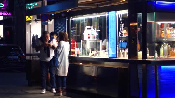 VIENNA, AUSTRIA - AUGUST 11, 2017. People eating fast food at the street booth in the evening — Stock Video