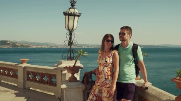 Pareja joven de pie en la terraza con vistas al mar — Vídeo de stock