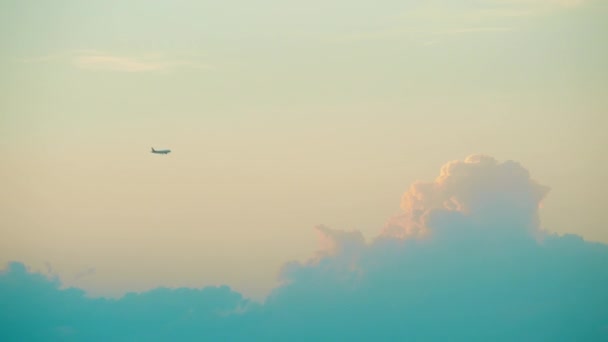 Vzdálených komerční letadlo letící proti krásný západ slunce mraky — Stock video