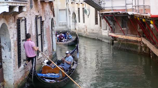 VENECIA, ITALIA - 8 de agosto de 2017. Góndolas venecianas con turistas moviéndose a lo largo del estrecho canal — Vídeo de stock