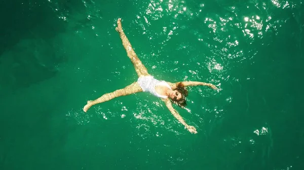 Vue aérienne du haut vers le bas d'une belle jeune femme en maillot de bain blanc baignant dans la mer — Photo