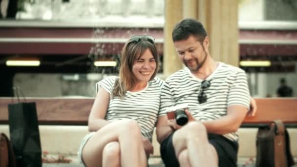 Jovem casal feliz assistindo fotos na câmera compacta em suas férias — Vídeo de Stock