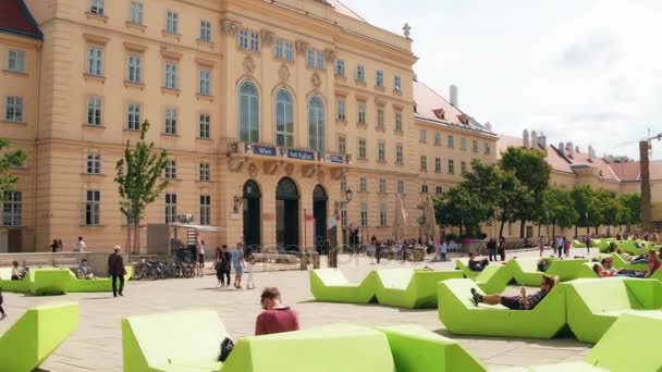 Vienna, Oostenrijk - 12 augustus 2017. Jonge mensen ontspannen op groene bankjes op het Museumsquartier gebied — Stockvideo