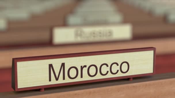 Morocco name sign among different countries plaques at international organization — Stock Video