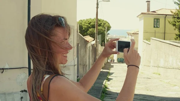 Jovem mulher fazendo fotos da antiga rua da cidade mediterrânea com seu smartphone — Fotografia de Stock