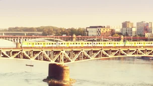 WARSAW, POLAND - AUGUST 30, 2017. Aerial shot of an electric train moving on the railroad bridge over the Vistula river in the evening — Stock Video