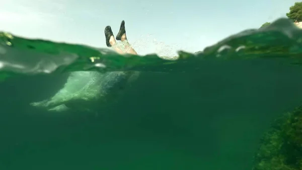 Ung man dykning i havet, vattenlinjen sköt — Stockfoto