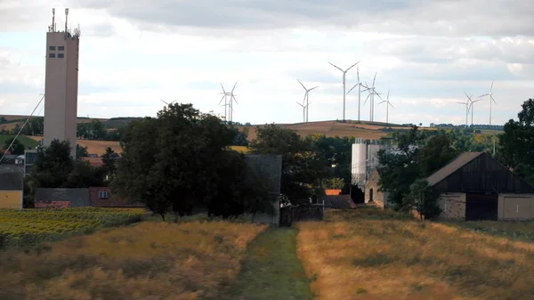 Geradores de vento, campos e vilarejo na Áustria como visto do carro — Fotografia de Stock
