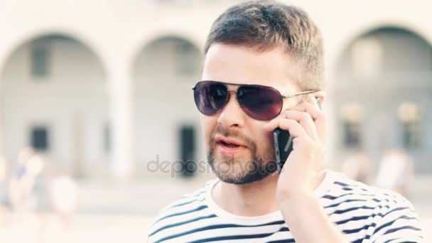 年轻英俊的大胡子的男人谈他在大街上的移动电话 — 图库视频影像