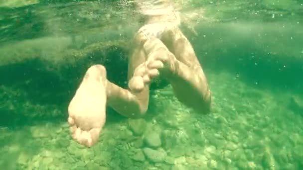 Beautiful young woman in white swimsuit bathing in the sea, underwater shot — Stock Video