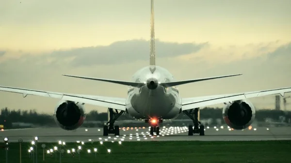 Twin motor avião comercial a partir de decolagem do aeroporto à noite, vista traseira — Fotografia de Stock