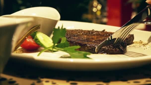 Manger steak fumant juteux dans un restaurant, plan rapproché de la plaque — Video