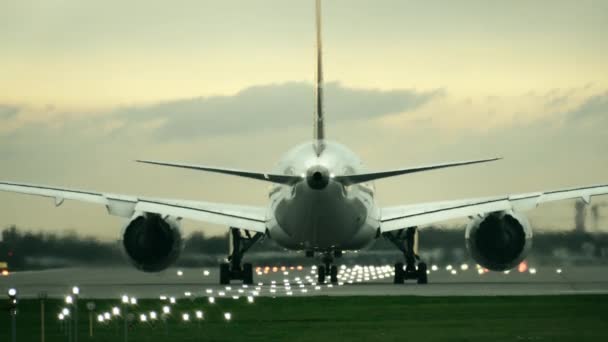 ツイン エンジンの商業飛行機の夜、リア ビューで空港から離陸を開始 — ストック動画