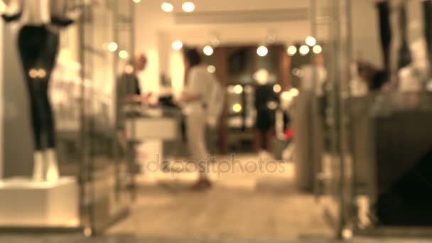 Πωλητής στο κατάστημα σε ένα σύγχρονο εμπορικό κέντρο και θολή θηλυκό πελάτη — Αρχείο Βίντεο