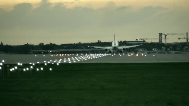 Twin engine commerciële vliegtuig landing op de luchthaven in de avond, achterste weergave — Stockvideo