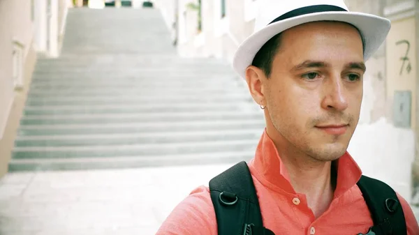 Sad male traveller wearing hat walks downstairs on the street — Stock Photo, Image