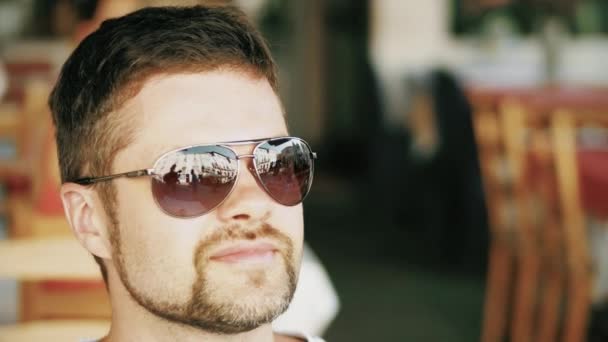 Portret van de jonge knappe bebaarde man dragen van een zonnebril — Stockvideo