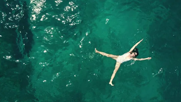 Letecká shora dolů záběr krásné mladé ženy v bílém plavkách, koupání v moři — Stock fotografie