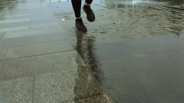 Super cámara lenta primer plano de los pies de las corredoras corriendo bajo la lluvia — Vídeos de Stock