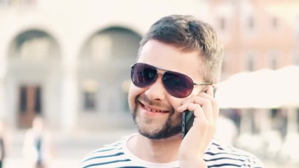 Homem bonito feliz falando em seu telefone celular na rua, close-up tiro — Vídeo de Stock