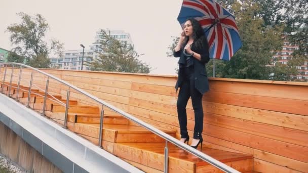 Молода змішана гонка бізнес-леді розмовляє на мобільному телефоні під дощем — стокове відео