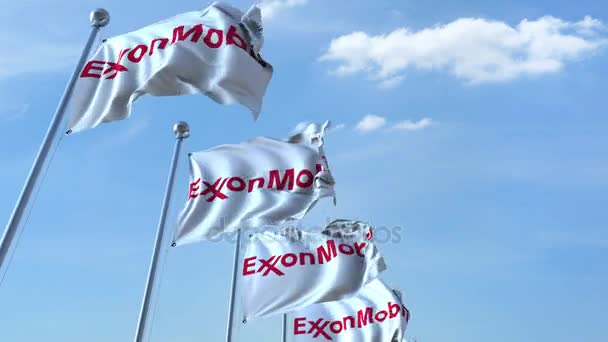 Ondeando banderas con el logotipo de Exxon Mobil contra el cielo, lazo sin costuras. Animación editorial 4K — Vídeo de stock