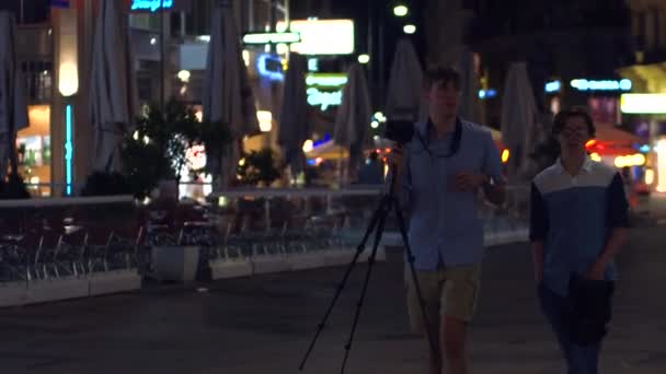 VIENA, AUSTRIA - 11 de agosto de 2017. Jóvenes fotógrafos caminando con un trípode por la noche — Vídeos de Stock