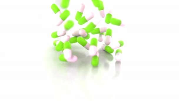 Green and white drug capsules or pills scattering on the table, slow motion — Stock Video
