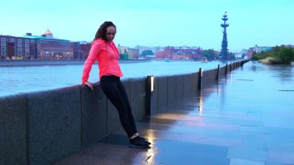 Mladá smíšený závod sportovní ženu rozcvička před spuštěním podél nábřeží park city večer — Stock video