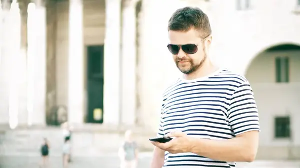Sokakta onun akıllı telefon kullanan genç yakışıklı adam — Stok fotoğraf