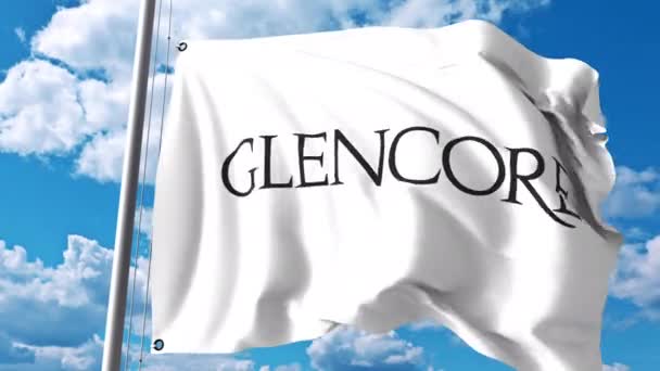 Размахивание флагом с логотипом Glencore plc против облаков и неба. Редакция 4K — стоковое видео