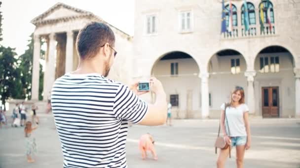 Unga lyckliga paret gör foton i en turist plats på sin semester — Stockvideo
