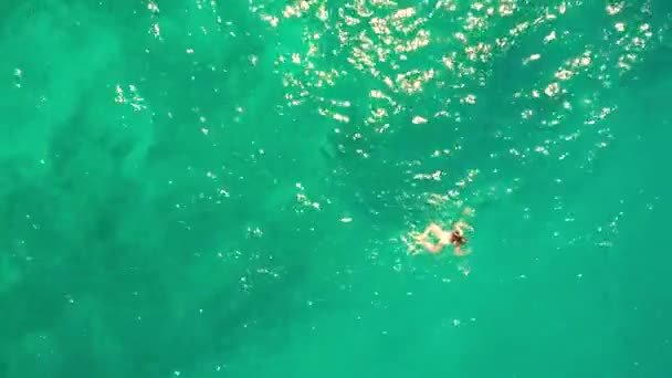 Повітря зверху вниз знімок молодої жінки, що плаває в морі — стокове відео