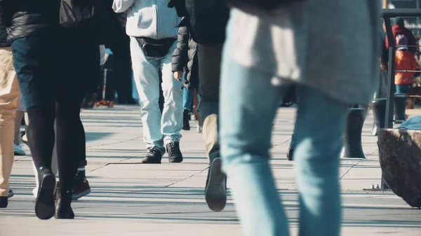 Unrecognizable people walk along pedestrian city street