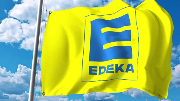 Wapperende vlag met Edeka Groepslogo tegen wolken en lucht. Redactioneel 3D-rendering — Stockfoto