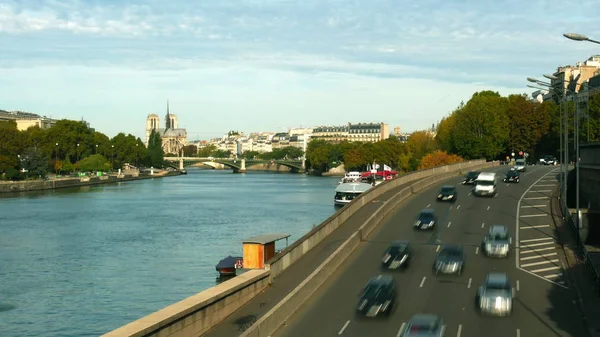 Caducidad del tráfico de automóviles en el dique del río Sena en París y la lejana Catedral de Notre-Dame, Francia —  Fotos de Stock