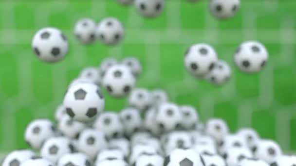 Falling football balls against green field background — Stock Video