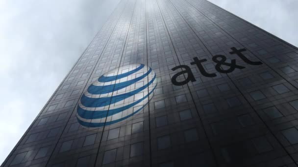 Логотип American Telephone and Telegraph Company AT T на фасаде небоскреба, отражающем облака, время истекло. Редакционная 3D рендеринг — стоковое видео