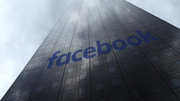 Логотип Facebook на фасаде небоскреба, отражающий облака, время истекло. Редакционная 3D рендеринг — стоковое видео