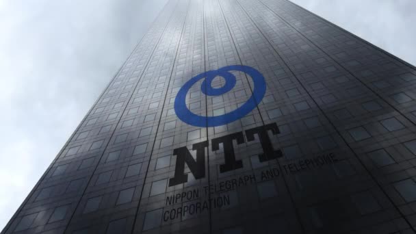 Nippon Telegraph and Telephone Corporation logotipo NTT en una fachada de rascacielos que refleja nubes, lapso de tiempo. Representación Editorial 3D — Vídeo de stock