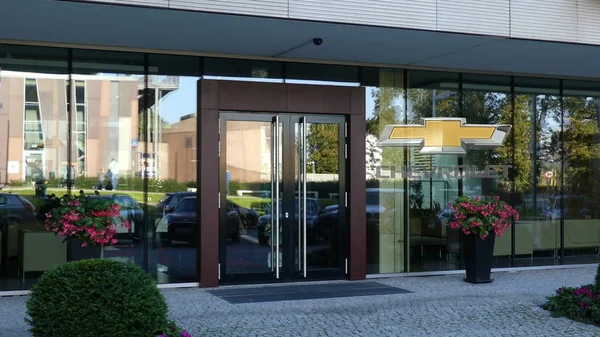 Fachada de cristal de un moderno edificio de oficinas con logo Chevrolet. Representación Editorial 3D — Foto de Stock