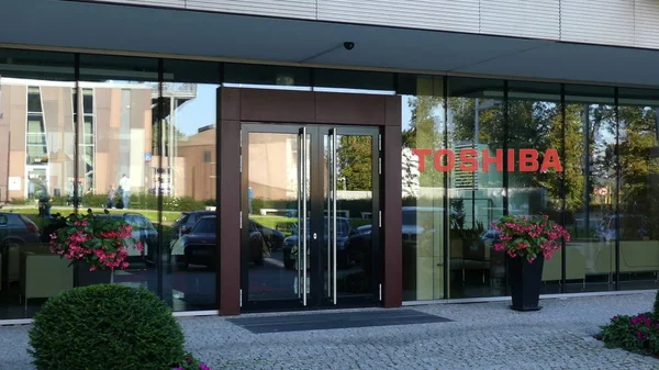 Fachada de cristal de un moderno edificio de oficinas con el logotipo de Toshiba Corporation. Representación Editorial 3D — Foto de Stock